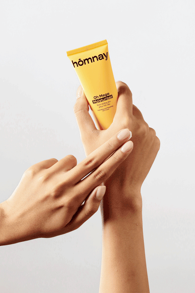 hands applying homnay beauty oh mega moisturizer cream