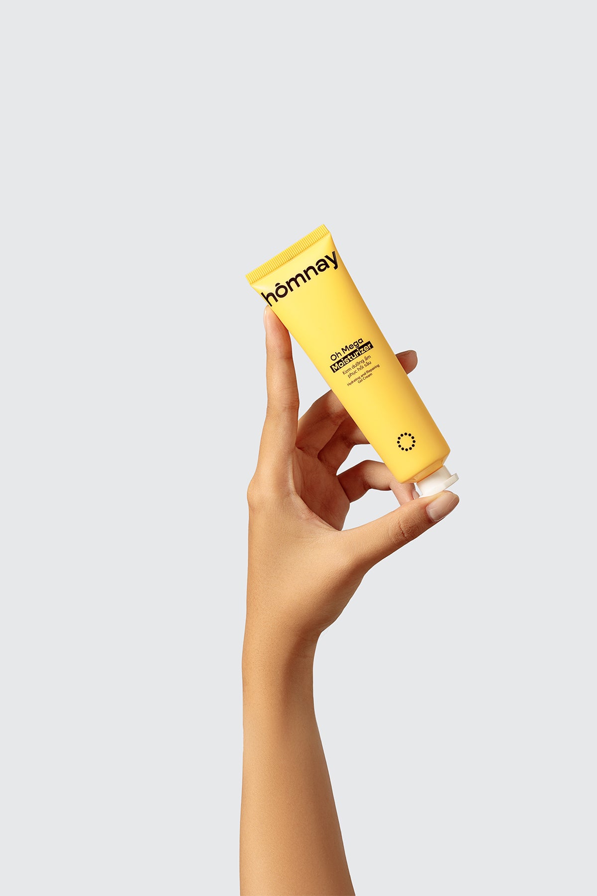 hand holding yellow tube of homnay beauty oh mega moisturizer